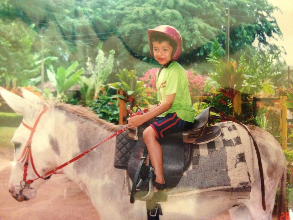 Usman as a young boy riding a donkey