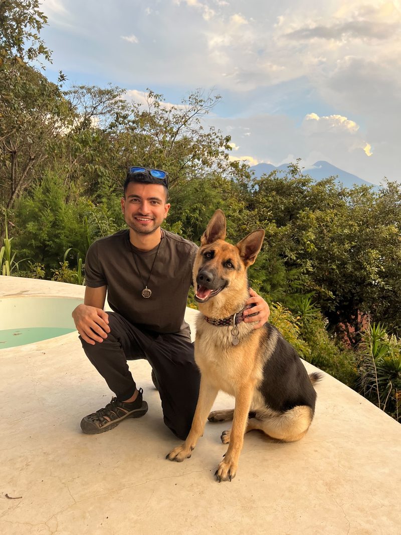 Usman crouching beside a German Shepherd